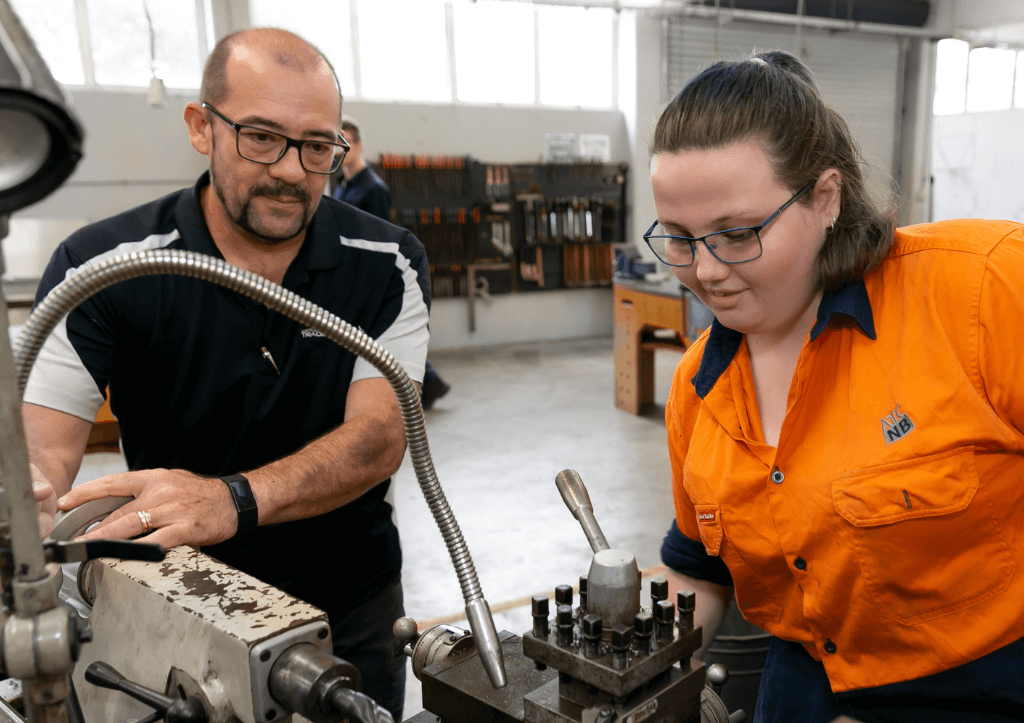 ATCNB female metal engineering student at lathe with trainer