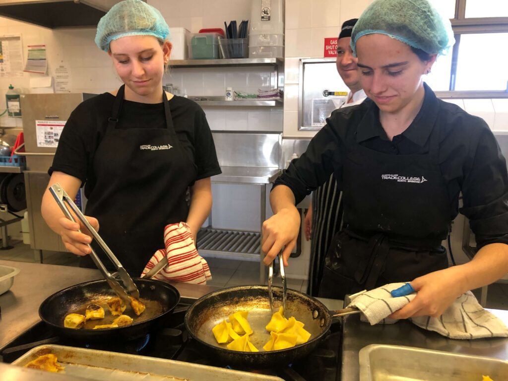 Two female chef students cooking dumpings
